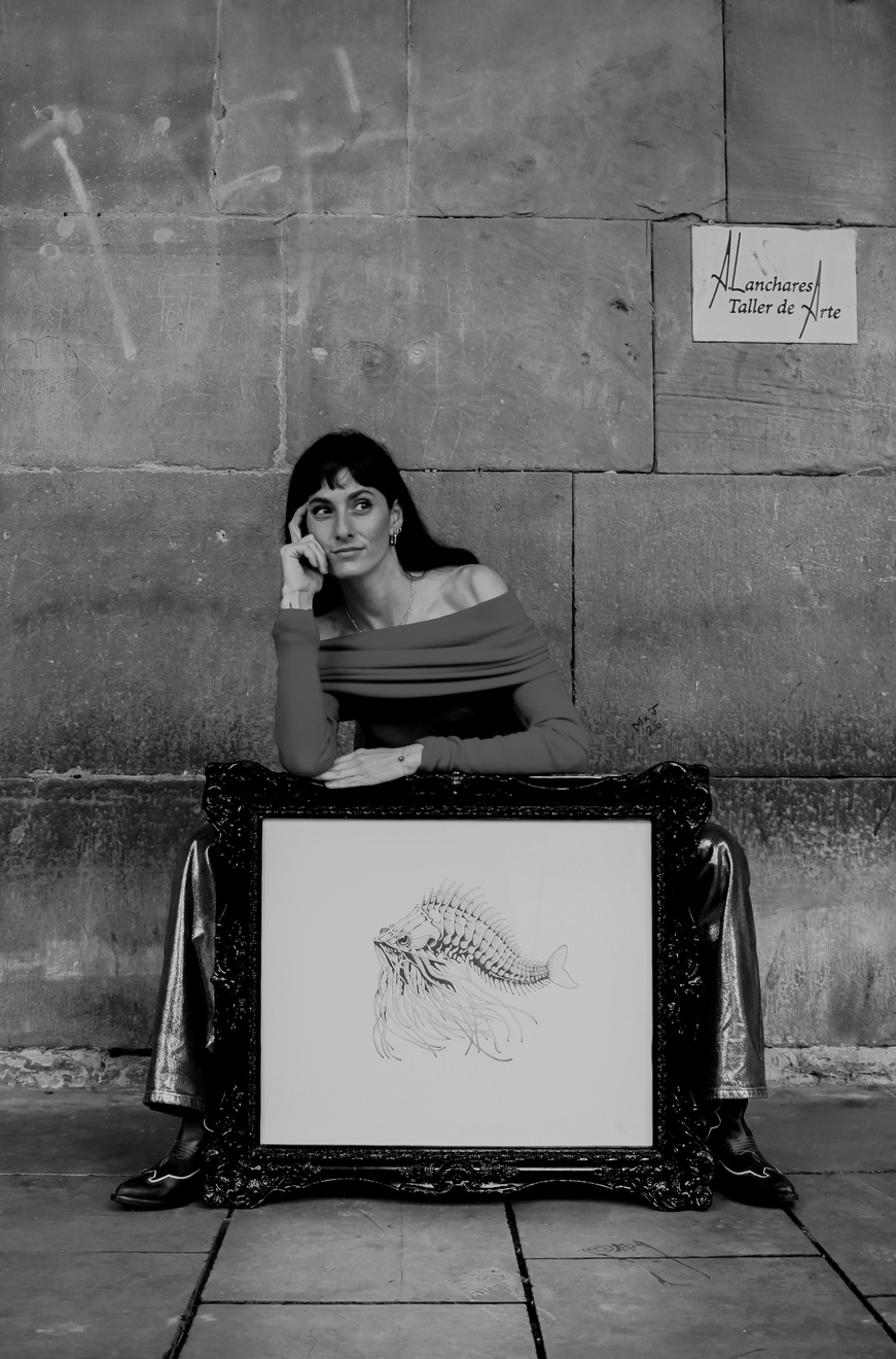 Retrato en blanco y negro de Valeria junto a una obra enmarcada